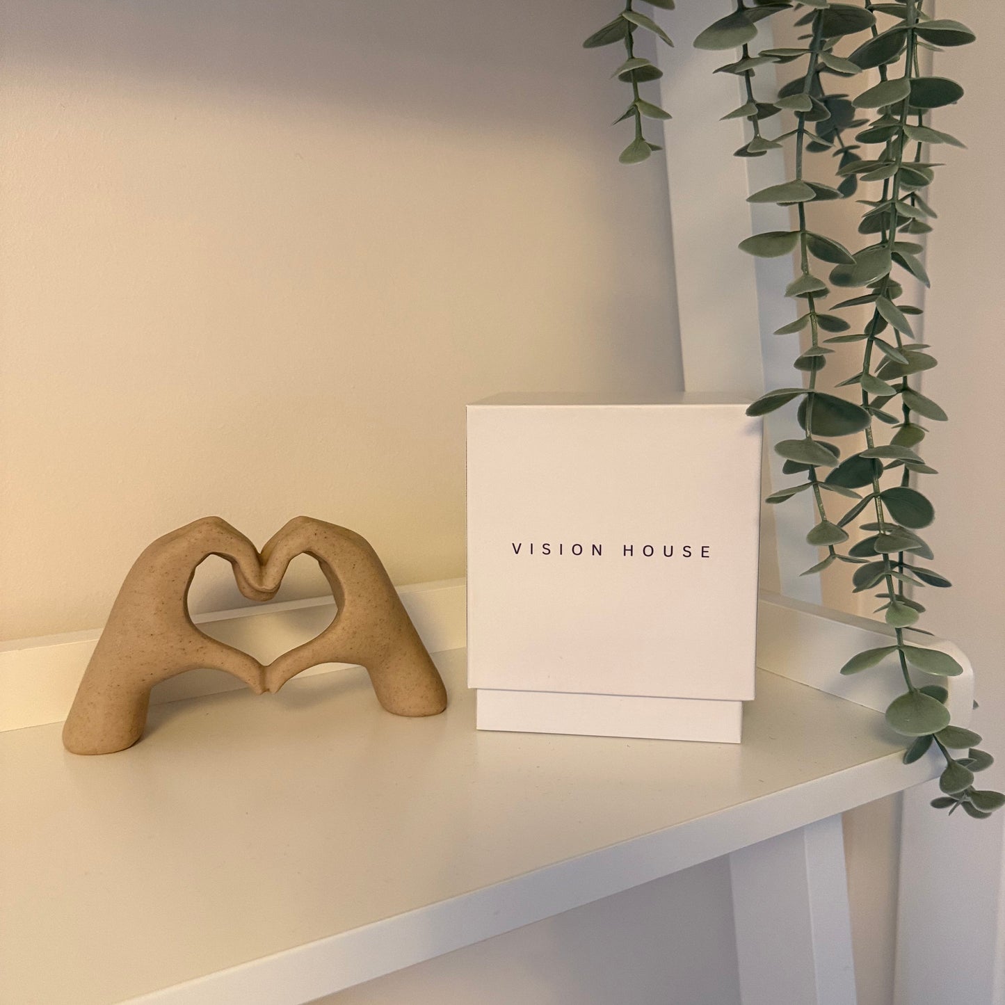 Decorative heart-shaped object on a shelf with a Vision House branded box 